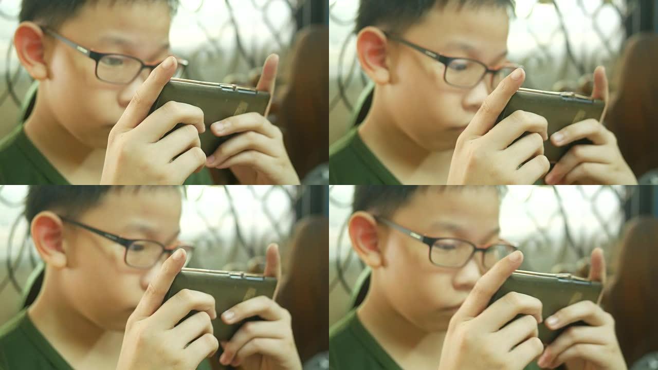 亚洲男孩使用智能手机的数字游戏
