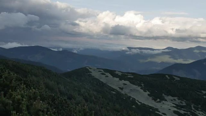 云杉在山顶上有圆锥体，背景是快速运行的云。平稳运动