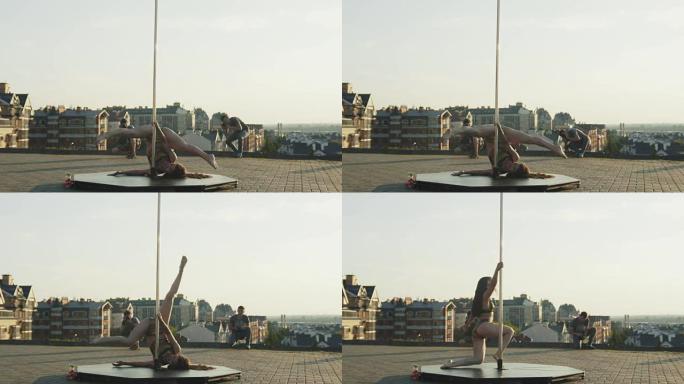 运动性感迷人的女孩模特摆姿势在市中心的杆子上为两位摄影师，广角