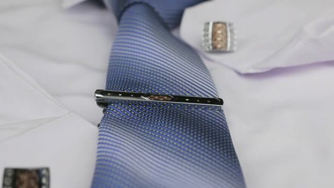 多莉射门，专注于蓝色领带、袖扣、扣子、白衬衫。