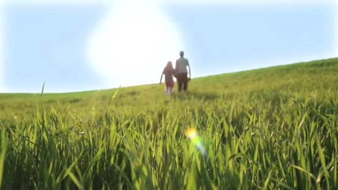 孩子们正从绿色的草地上走向灿烂的阳光。