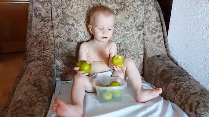 可爱的孩子在扶手椅上吃梨