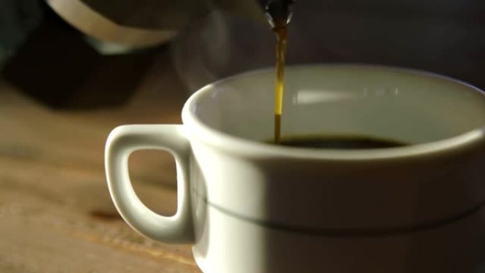 使用倒入白色杯子中的饮料的咖啡间歇泉准备一杯浓的新鲜冲泡的浓缩咖啡