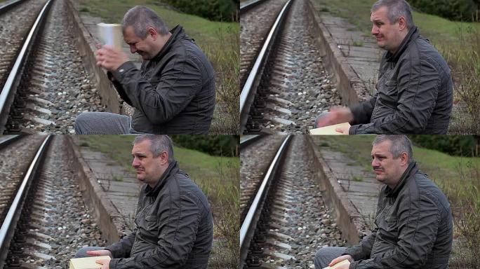 铁路附近有书籍的沮丧男子