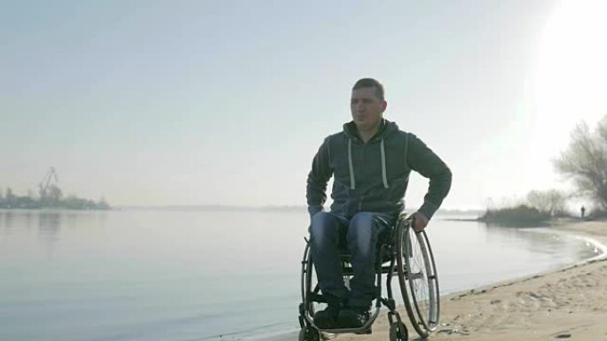 残疾人坐着轮椅去海边的堤岸，写真