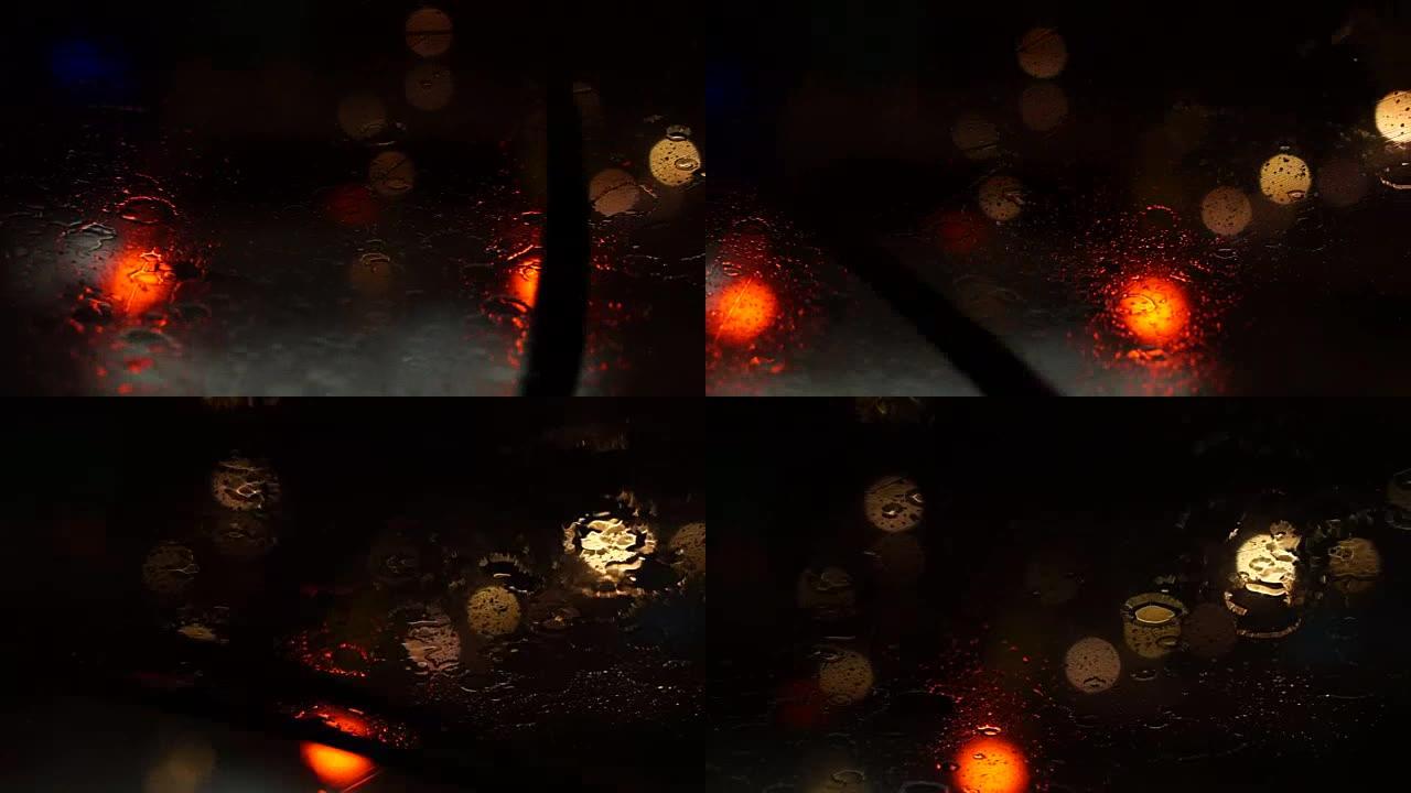 道路上美丽多彩的模糊交通视频。雨水流动和雨刷在汽车前风挡玻璃上