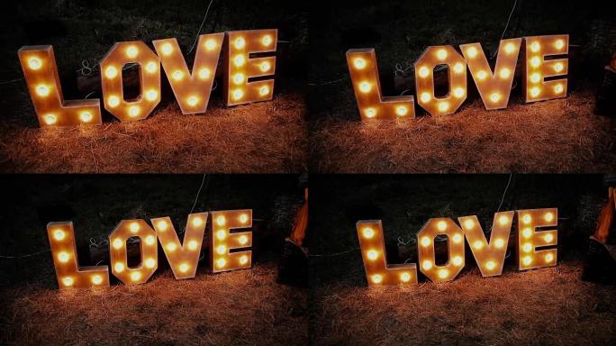 爱字由字母组成，晚上灯泡站在草坪上突出显示。