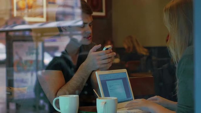 咖啡馆里有智能手机和笔记本电脑的年轻人
