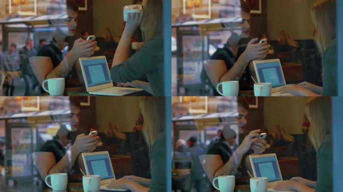 咖啡馆里有智能手机和笔记本电脑的年轻人