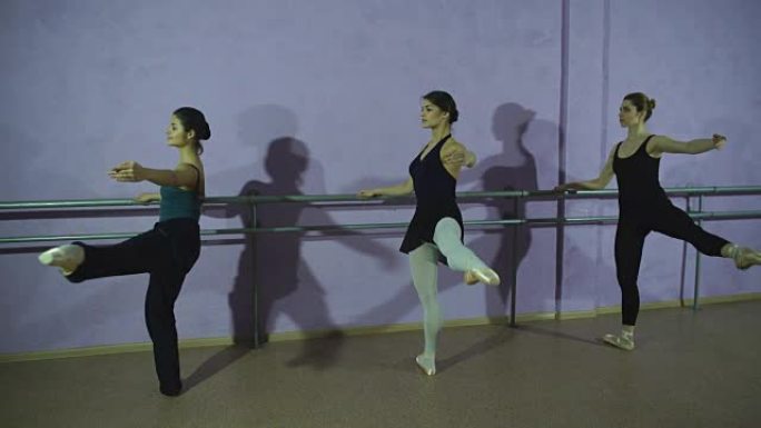 三名芭蕾舞演员在舞蹈工作室的芭蕾舞演员中练习