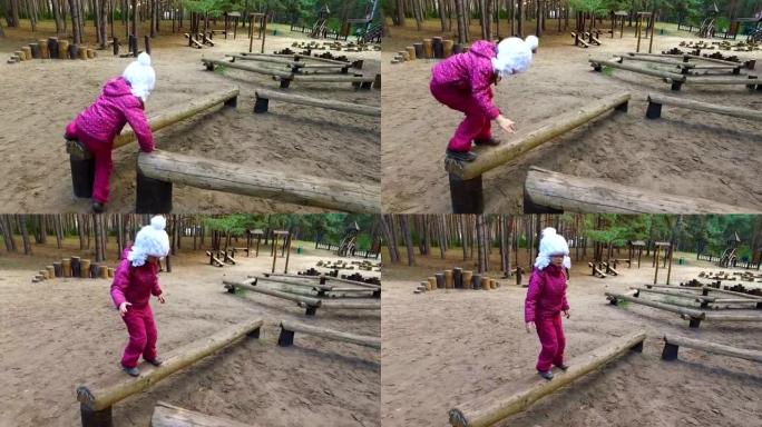 戴眼镜的女童从事木制原木。小德奥夫卡在操场上玩耍。
