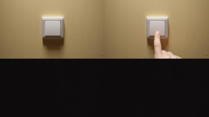 灯熄灭-人手关闭黄色墙壁上的按钮