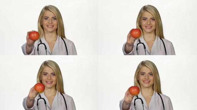 医生在相机上显示了一个红苹果。白色