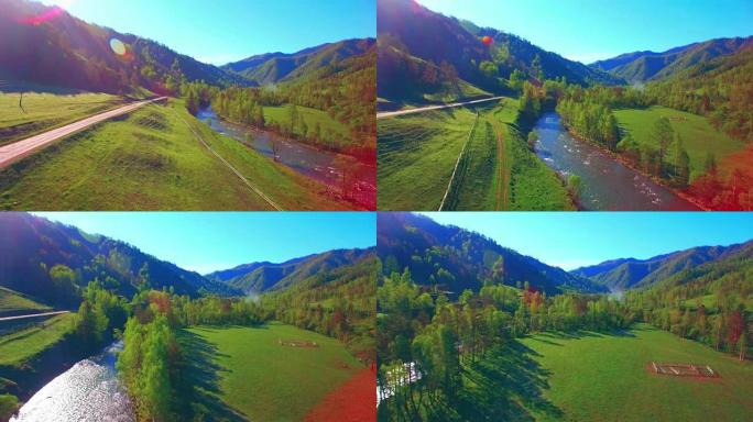 在阳光明媚的夏日早晨，空中飞行在新鲜的山河和草地上。下面的乡村土路