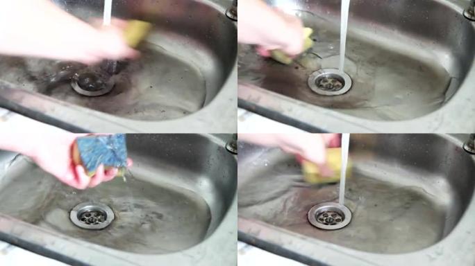 女人用海绵洗水槽的手。