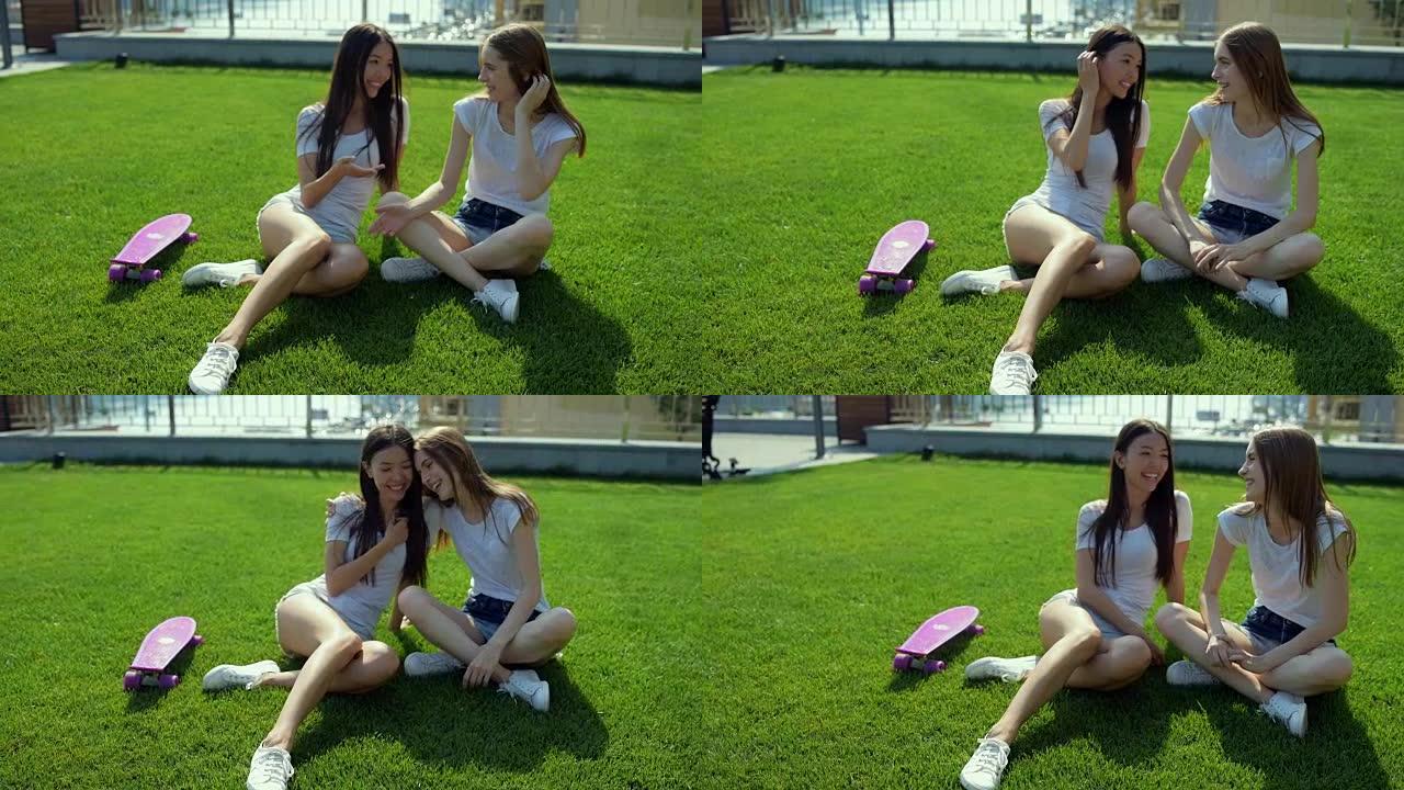 两个漂亮的女孩坐在草地上