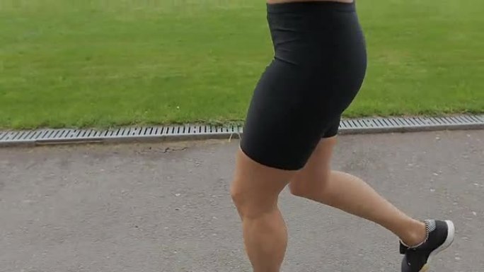 Runner女人在户外跑步和锻炼健身追踪器，并运行应用程序可穿戴技术与智能手机和耳机。