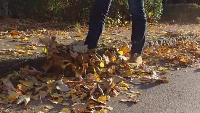 男人脚上穿着秋叶靴，走在落叶上
