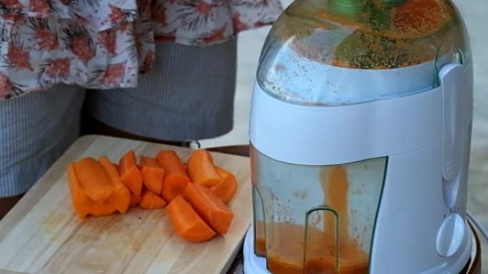 现代电动搅拌机用胡萝卜制成果汁。生胡萝卜汁