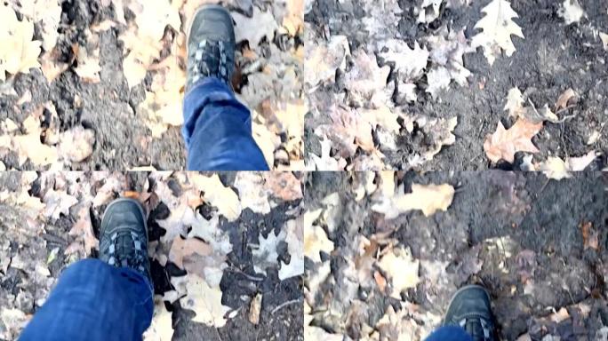 穿着牛仔裤和登山靴的人的脚在地上行走