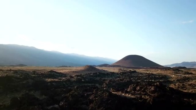 日落时缓慢揭示遥远的煤渣锥和火山平原