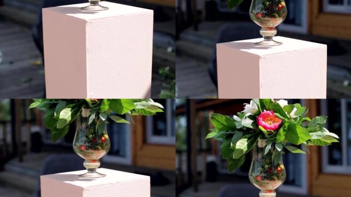 在阳光明媚的夏日，由狗玫瑰在浅粉色石质基座上开花的玻璃虎钳