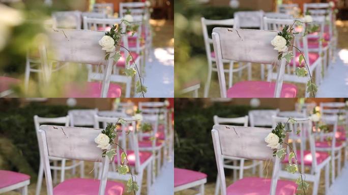 婚礼仪式的惊人乡村装饰，干草、椅子、花卉组合和婚纱挂在背景上。夏季乡村婚礼概念