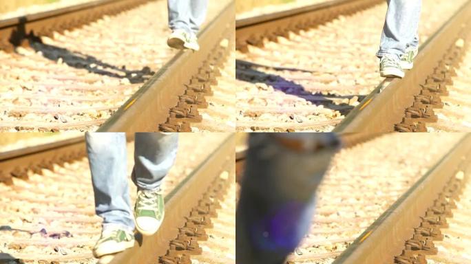 一个少年穿着运动鞋在铁路上昂首阔步的镜头