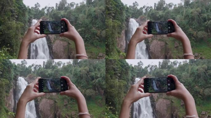 妇女在考艾国家公园瀑布用智能手机拍照