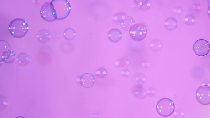 粉红色，背景，慢动作上的蓝色和透明肥皂泡