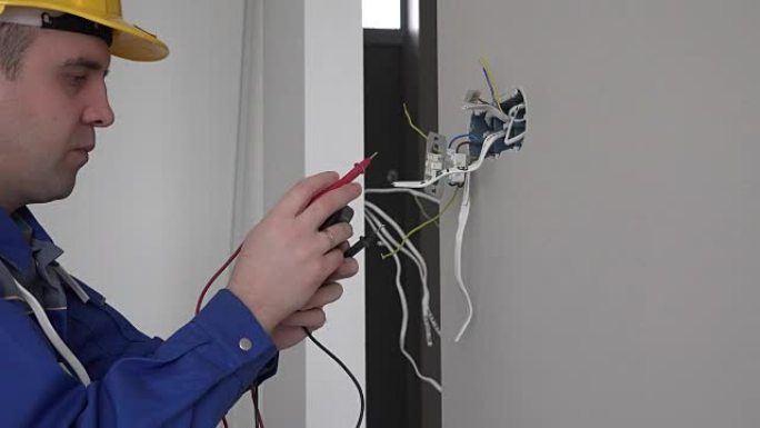电工使用万用表在墙壁夹具插座中检查插座电压