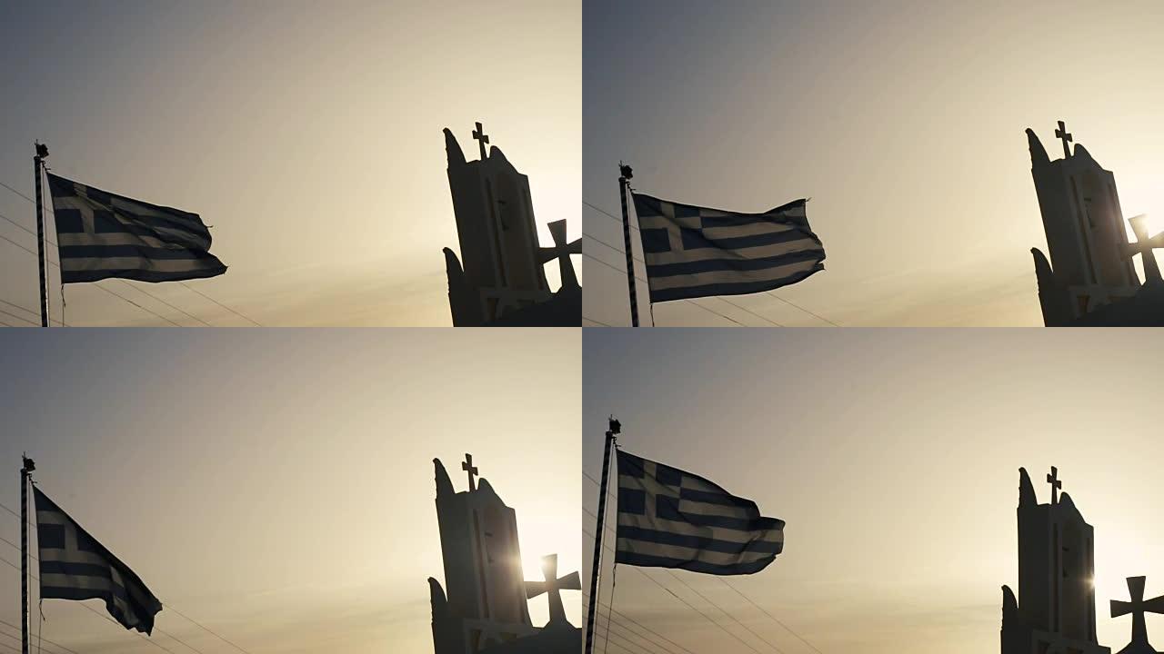 希腊圣托里尼岛Oia的白色教堂顶部，带有希腊国旗和蓝色的大海。