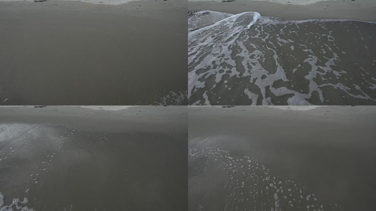沙滩与海浪覆盖和下降，泡沫表面和螺旋清澈的水