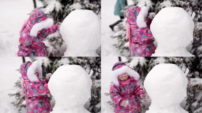 女孩在冬天的雪地里雕刻雪人。