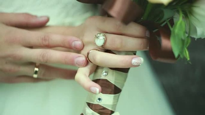 新郎手抚摸新娘，结婚戒指，鲜花，乌克兰