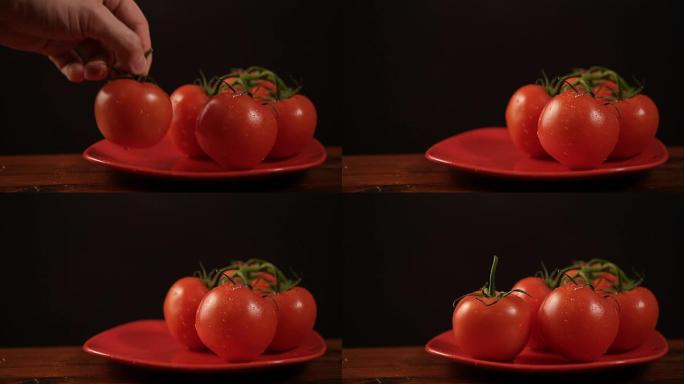 从红色盘子里拿一个成熟的西红柿，然后放回去
