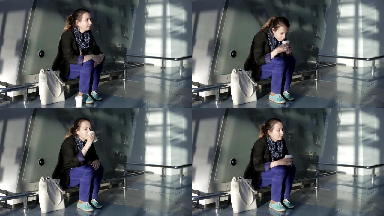 悲伤的女人坐在候机室喝咖啡，等待下一班飞机。