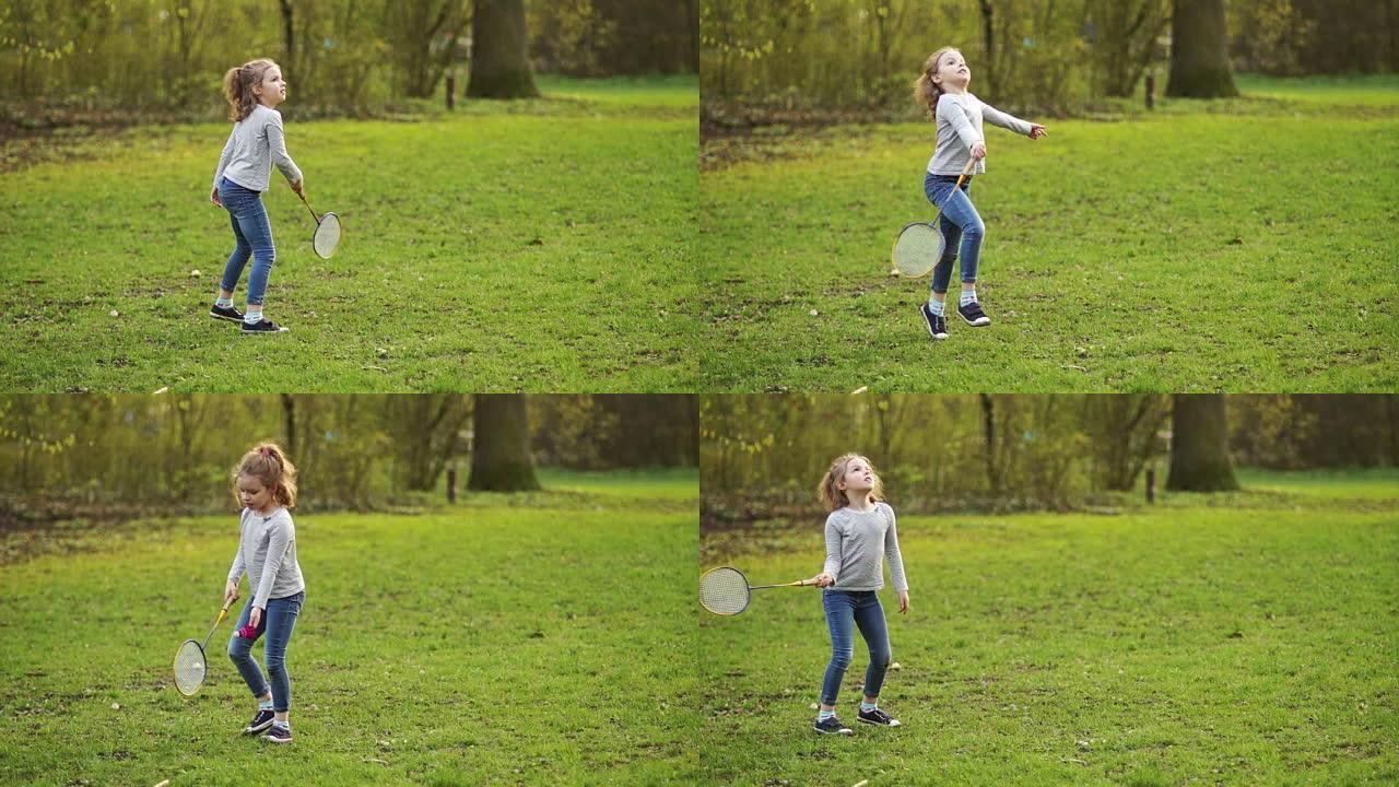 卷曲的漂亮女孩在公园打羽毛球。