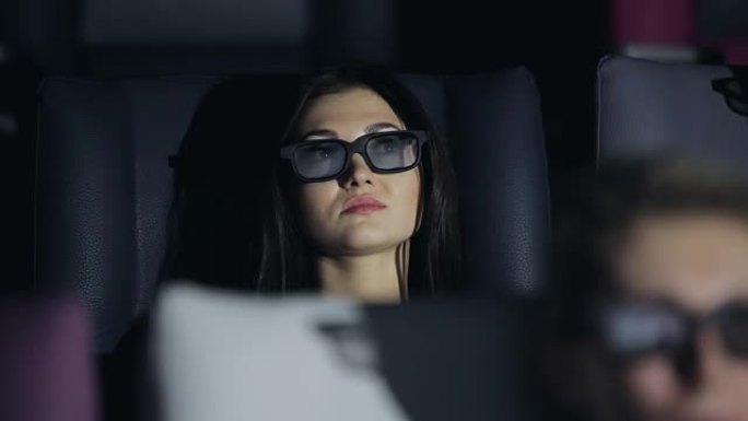 戴着3D眼镜的年轻女子在电影院看电影
