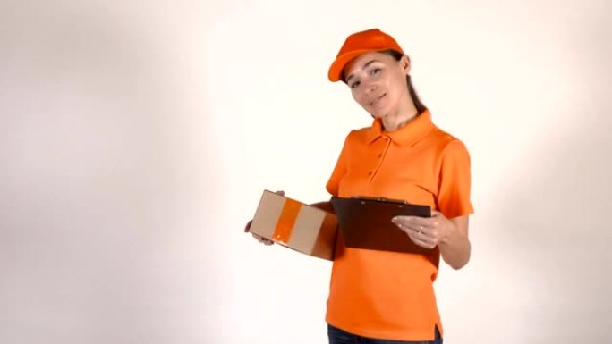 穿着橙色制服的女快递员拿着一个纸板箱。全高清工作室拍摄，孤立