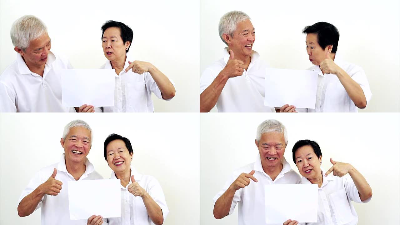 亚洲老年夫妇一起看白色标志。对空白白色标志的交易感到惊讶和满意