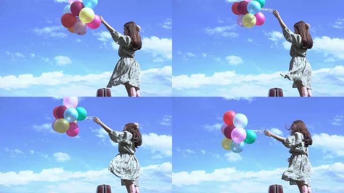 美丽的女孩在户外拿着一个气球，背景是山河。设想亚洲女孩明亮的快乐。