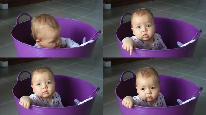 婴儿在洗衣篮里玩耍