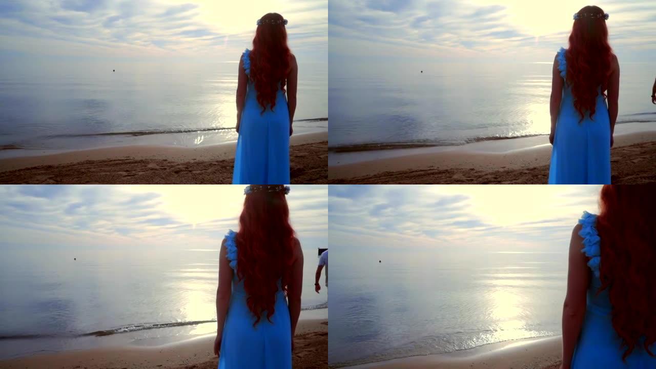 女人看着海上日落。日落时站在海滩上的女人的后景