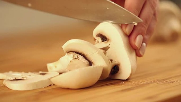 用银刀在木盘上切蘑菇。