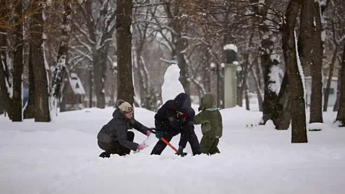 幸福家庭从雪中雕刻雪人