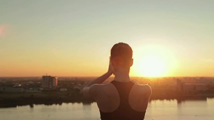 日落时在公园里练习瑜伽的运动女人 -- 太阳致敬