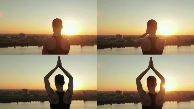 日落时在公园里练习瑜伽的运动女人 -- 太阳致敬
