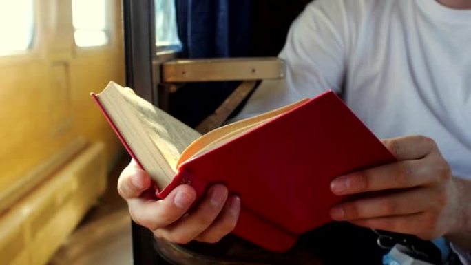 男人在火车上读红皮书。