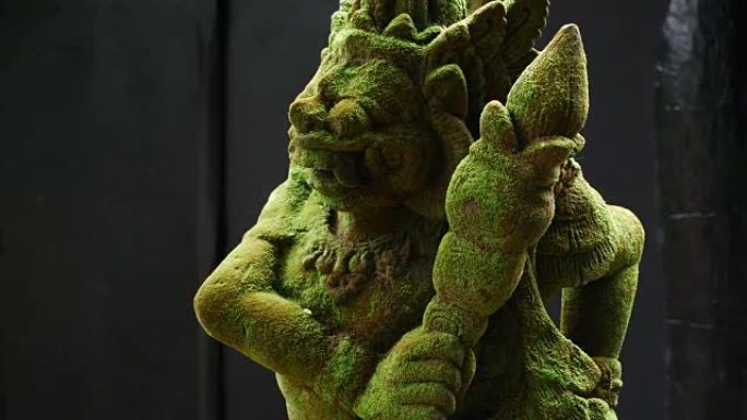 巴厘岛雕刻的拉卡萨石像覆盖着绿色苔藓。在印度教寺庙。